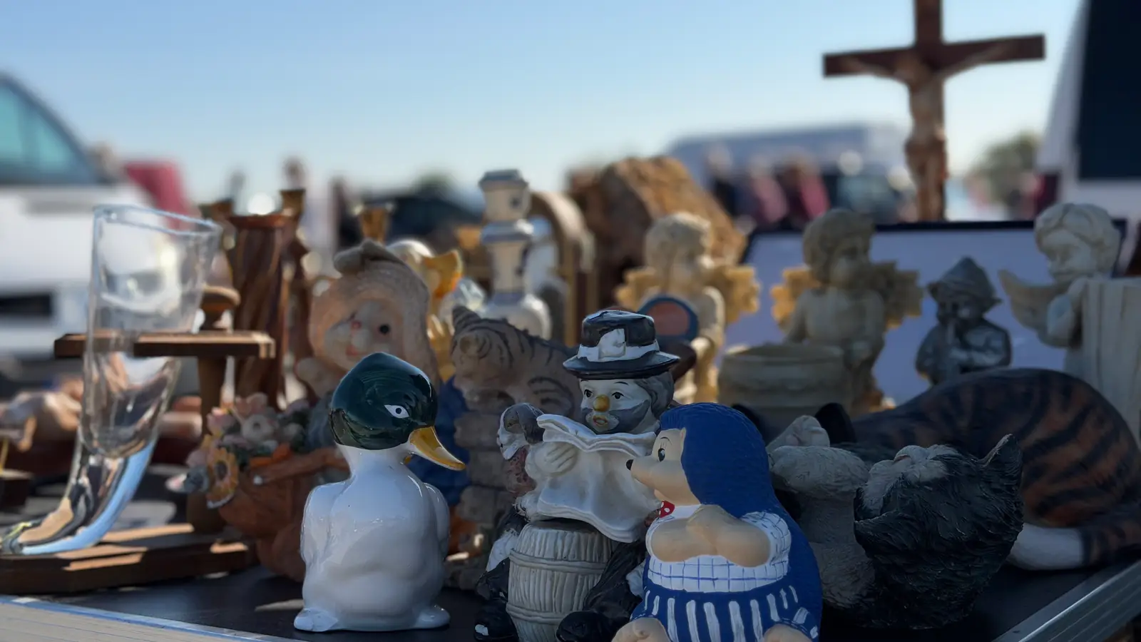 Porcelánové figurky kachny, kočky a andílků vyrovnané na stole