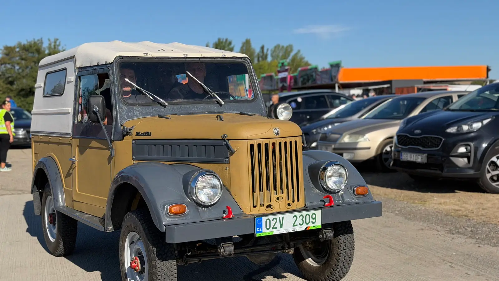 Vojenský terénní GAZ 69 s plátěnou střechou přijíždí na plochu